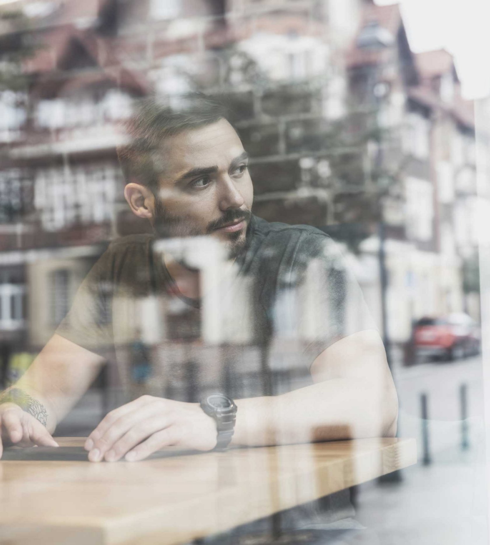 Mann schaut aus einem Fenster in einem Café